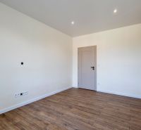 MODERNÝ 4-IZBOVÝ BUNGALOV | ZEMPLÍNSKA ŠIROKÁ - Prázdna izba s podlahou s dreveným dekorom a svetlými stenami v rodinnom dome.