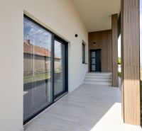 MODERNÝ 4-IZBOVÝ BUNGALOV | ZEMPLÍNSKA ŠIROKÁ - Rodinný dom v Zemplínskej Širokej s terasou, drevenými detailmi a trávnikom.