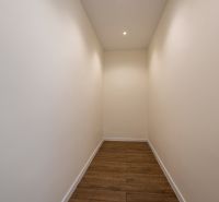 MODERNÝ 4-IZBOVÝ BUNGALOV | ZEMPLÍNSKA ŠIROKÁ - Úzka chodba v rodinnom dome s bielymi stenami a podlahou s dreveným dekorom.