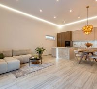 MODERNÝ 4-IZBOVÝ BUNGALOV | ZEMPLÍNSKA ŠIROKÁ - Interiér rodinného domu s otvorenou kuchyňou, sedacou súpravou a podlahou s dreveným dekorom.
