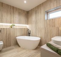 MODERNÝ 4-IZBOVÝ BUNGALOV | ZEMPLÍNSKA ŠIROKÁ - Kúpeľňa v rodinnom dome s podlahou s dreveným dekorom, vaňou a dekoratívnym osvetlením.