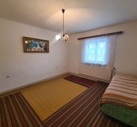Na predaj rodinný dom Dulovce ! - Interiér rodinného domu s posteľou, obrazom a oknom so záclonami.