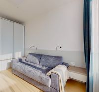 SKY PARK 3izbový byt a výhľad na hrad - Obývačka v 3-izbovom byte s pohovkou, vstavanou skriňou a podlahou s dreveným dekorom.
