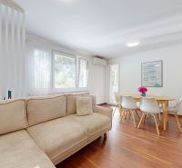 3-izbový byt 65m2 + loggia 5m2 | Na pasekách - Štýlový obývací priestor s pohovkou, jedálenským stolom a podlahou s dreveným dekorom.