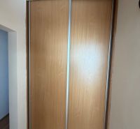 3 izbový byt s balkónom v meste Levice - Skriňa so zasúvacími dverami a podlahou s dreveným dekorom v 3-izbovom byte.