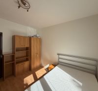 3 izbový byt s balkónom v meste Levice - Spálňa v 3-izbovom byte s bielymi stenami a podlahou s dreveným dekorom.