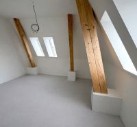 PODKROVNÝ 2 IZB. BYT (56m2), REZIDENCIA SADOVÁ, SENICA - Podkrovná izba s bielou stenou a drevenými trámami v 2-izbovom byte.
