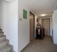 Predaj RD s pozemkom 1008 m2, Trenčín - Istebník - Vstupná chodba rodinného domu s podlahou s dreveným dekorom a schodiskom.