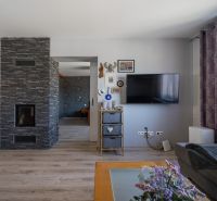 Predaj RD s pozemkom 1008 m2, Trenčín - Istebník - Interiér rodinného domu s televízorom, dekoráciami a podlahou s dreveným dekorom.
