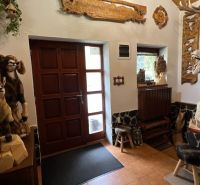 Na predaj penzion  – Štôla, Vysoké Tatry O560ZL - Interiér vily s drevenými sochami zvierat a vyrezávanými dekoráciami na stenách.