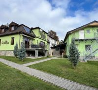 Na predaj penzion  – Štôla, Vysoké Tatry O560ZL - Vila vo Štôle, okres Poprad, Prešovský kraj s farebnou fasádou a záhradou.