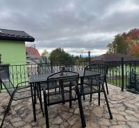 Na predaj penzion  – Štôla, Vysoké Tatry O560ZL - Terasa Vily v Štôle, okres Poprad, Prešovský kraj, so stolom a kovovými stoličkami.