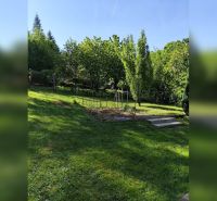 Exkluzívne na predaj, čarovný rodinný dom / chalupa v lone prírody - Záhrada pri rodinnom dome v Horných Otrokovciach, zelený trávnik a ovocné stromy.