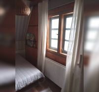 Exkluzívne na predaj, čarovný rodinný dom / chalupa v lone prírody - Izba v rodinnom dome s tmavým dreveným obkladom a posteľou pri okne.