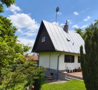 Exkluzívne na predaj, čarovný rodinný dom / chalupa v lone prírody - Rodinný dom na ulici Horné Otrokovce v Horných Otrokovciach obklopený zeleňou a modrou oblohou.