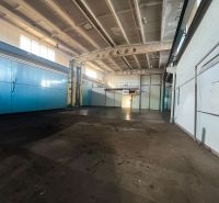 Na prenájom priestor 378 m² s vykurovaním — Banská Bystrica, Majer  - Výrobné priestory s vysokým stropom, ktoré majú bledomodré dvere a trubky na stenách.