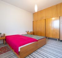 TOP LOKALITA - 3i 67m2 + loggia - Švermova Trenčín - Spálňa v 3-izbovom byte s dreveným nábytkom a pruhovaným kobercom.