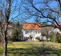 ROVINATÝ POZEMOK S PRÍSTUPOM Z DVOCH STRÁN+ RODINNÝ DOM – B. Bystrica - Rodinný dom v Podháji, Kráľovej, obklopený stromami a trávnikom, s oranžovou strechou.