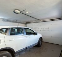 NA PREDAJ priestranný 7-izbový rodinný dom s dvojgarážou v Marianke - Auto zaparkované v garáži rodinného domu s bielymi stenami a podlahou dlaždicami.