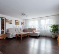 NA PREDAJ priestranný 7-izbový rodinný dom s dvojgarážou v Marianke - Obývacia izba v rodinnom dome s pohovkou, televízorom a podlahou s dreveným dekorom.