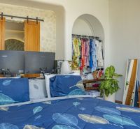 PREDAJ Unikátná 4KK Investičná zariadená vila s bazénom BALI-Jimbaran - Spálňa vo vile s posteľou, zelenými rastlinami a otvoreným šatníkom.