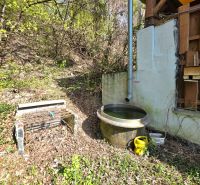 : Záhrada s chatkou, Košice – Krásna, 716 m², elektrina - Drevená konštrukcia chaty a dažďový sud v záhrade na Ulici 1. mája, Krásna.