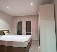   Exkluzívne na predaj Mezonetový apartmán Turecko- Side A205BD - Spálňa v Rekreačnom apartmáne s veľkou posteľou, bielymi a šedými stenami.