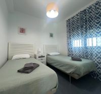 Exkluzívna ponuka – apartmán-byt v „Malom Miami Španielska  - Rekreačný apartmán s dvomi jednolôžkovými posteľami, vzorovanými závesmi a stolíkom s lampou.