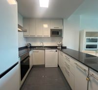 Exkluzívna ponuka – apartmán-byt v „Malom Miami Španielska  - Kuchyňa rekreačného apartmánu s lesklými skrinkami a tmavou pracovnou doskou.