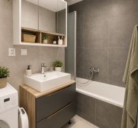 NOVOSTAVBA , BAŠTOVÁ 48 M2 2-IZBOVÝ BYT S LOGGIOU  - Kúpeľňa v 2-izbovom byte s vaňou, skrinkami a práčkou, šedé dlaždice.