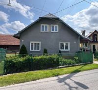 Na predaj útulný rodinný dom v krásnej prírode- Liptovská Lúžna  - Rodinný dom v Liptovskej Lúžnej so záhradou a plotom za slnečného dňa.