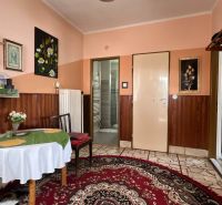 Predaj rodinného domu – Kalameny, Liptov - Izba v rodinnom dome zdobená obrazmi, stolom s obrusom a kobercom.