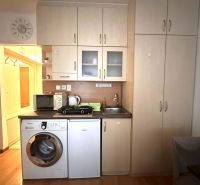☎️ 0918/197 701 Na prenájom garsónka s balkónom aj s výťahom   v centr - Kuchyňa v rekreačnom apartmáne s kuchynskou linkou a práčkou, podlaha s dreveným dekorom.