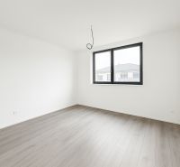 Moderný 4-izbový dom v tichej lokalite Šale – bez rezervačnej zálohy  - Priestranná prázdna izba v rodinnom dome s podlahou s dreveným dekorom a veľkým oknom.