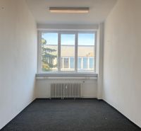 Prenájom centrum Galanty - Kancelárie s bielymi stenami a kobercom, veľké okno a radiátor pod ním.