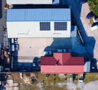 PREVÁDZKOVÝ AREÁL– HALA, ADMINISTRATÍVA, POZEMOK 1405 m² - B. Bystrica - Strechy budov so solárnymi panelmi a parkovisko, Stavebná v Majeri, Banská Bystrica.