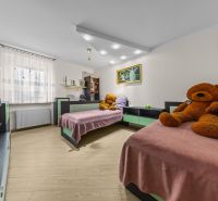 Priestranný terasový rodinný dom s garážou a terasou v Dúbravke. - Detská izba v rodinnom dome s dvoma posteľami, plyšovými medveďmi a podlahou s dreveným dekorom.