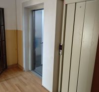 Na prenájom 1 izbový byt, 34 m2, Bratislava, Petržalka, Lachova ulica - Chodba s výťahom a podlahou s dreveným dekorom v 1-izbovom byte.