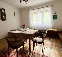 Predaj- Rodinný dom -Stankovany - Jedáleň v rodinnom dome s jednoduchým nábytkom, hodiny a kríž na stene.