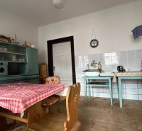 Predaj- Rodinný dom -Stankovany - Kuchyňa v rodinnom dome s retro nábytkom a podlahou s dreveným dekorom.