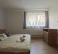 PPRENÁJOM APARTMÁNOVÉHO BYTU ONDRÁŠOVÁ ID: P2120BD - Jednoducho zariadená spálňa s posteľou a podlahou s dreveným dekorom v 2-izbovom byte.