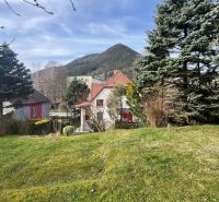 PREDANÝ !!! Rodinný dom v centre Ružomberka na PREDAJ ID:D130BD - Rodinný dom na ulici Makovického v Ružomberku, obklopený zeleňou a horami v pozadí.