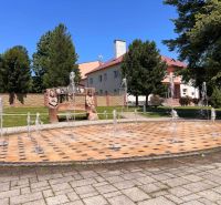 Rodinný dom pre veľkú rodinu s priestorom a súkromím – Polomka - Fontána a lavička s vyrezávanými postavami v obci Polomka.