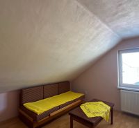 Rodinný dom pre veľkú rodinu s priestorom a súkromím – Polomka - Podkrovná izba v rodinnom dome s oknom a posteľou, podlaha s dreveným dekorom.