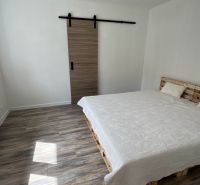 REZERVOVANÝ !!!!!!Víkendový rodinný dom pri Liptovskej Mare – Vlachy- - Spálňa v rodinnom dome s paletovou posteľou, posuvnými dverami a podlahou s dreveným dekorom.