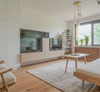 NOVINKA - 2 izbový + loggia + výťah v meste NOVÁ DUBNICA - Obývacia izba s podlahou s dreveným dekorom, pohovkou a izbovými rastlinami v 2-izbovom byte.
