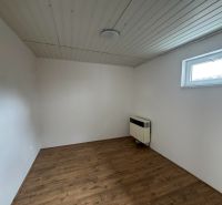 Prenajmem 2 izbový byt v Nesvadoch - Izba s podlahou s dreveným dekorom a bielymi stenami v 2-izbovom byte.