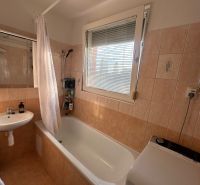 PREDAJ : 3 IZBOVÝ BYT S BALKÓNOM, KOMÁRNO  - Kúpeľňa v 3-izbovom byte s vaňou, umývadlom a práčkou, dlažba s teplými tónmi.