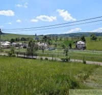 Slnečný stavebný pozemok 1 186 m² - Karná | možnosť dokúpiť 1 ha - Krajina v Karnej s výhľadom na kostol, domy a zeleň, Pozemky - bývanie.