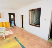 Na predaj 6-izbový rodinný dom (dvojdom) v Pažiti, pozemok 1445 m² - Interiér rodinného domu s plastovou stoličkou, dverami a elektrickou skrinkou na stene.
